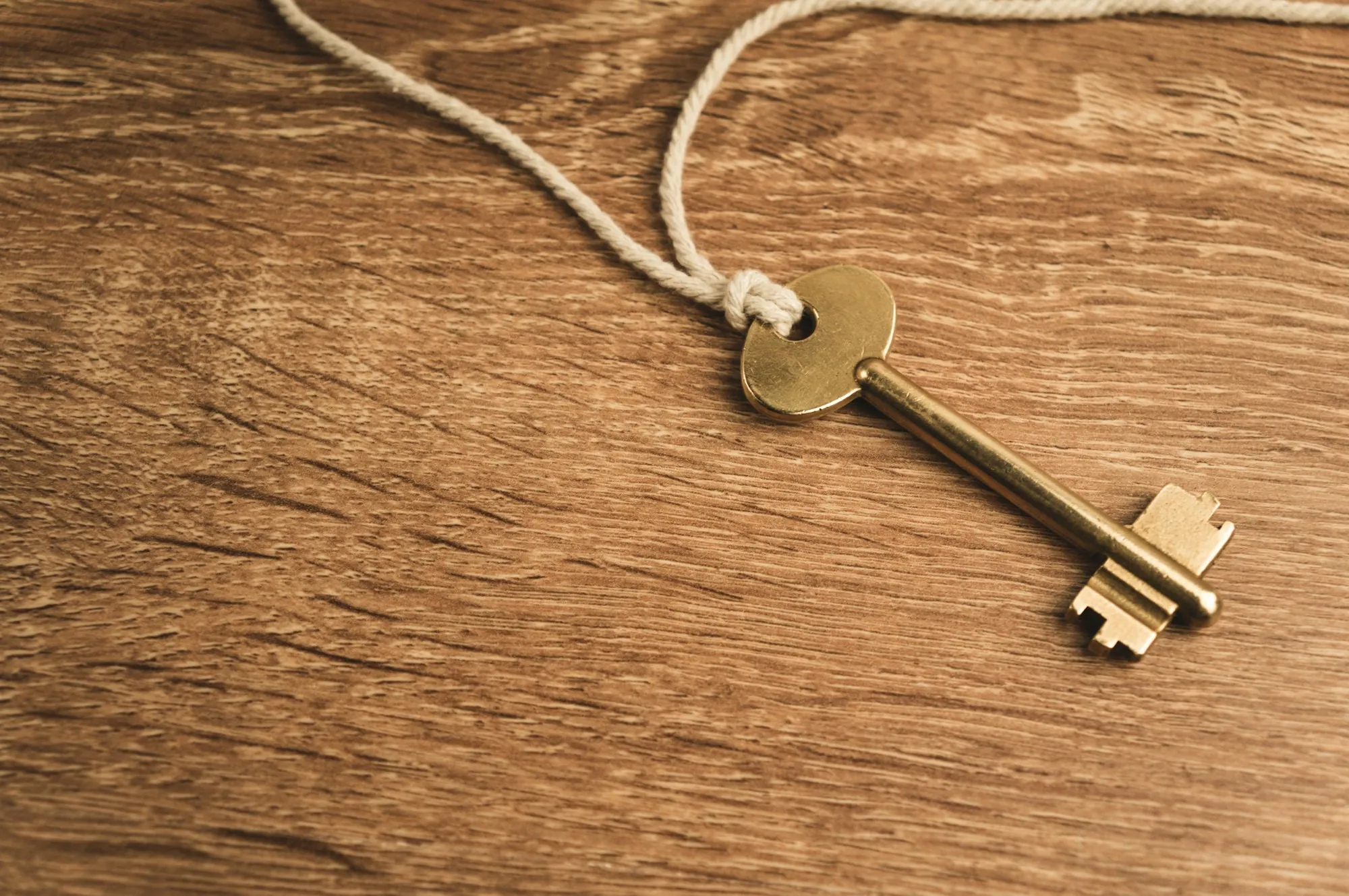 Old brass key on a wooden table